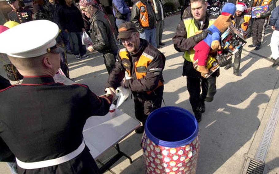 Yongsan Motorcycle Club members donate toys to the Marine Corps Toys For Tots collection drive Saturday at Yongsan Garrison, South Korea.