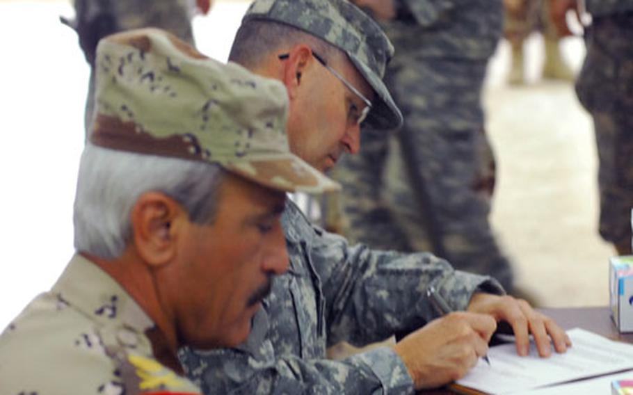 Iraqi Army Maj. Gen. Khorsheed Saleem Hassan Muhammad al-Dosky, left, and U.S. Maj. Gen. Benjamin R. Mixon sign documents during an official transfer of authority ceremony in northern Iraq Monday.