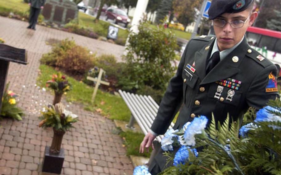 Sgt. Jorge Mora from 4th Battalion, 27th Field Artillery Regiment adjusts a wreath that was used during a memorial ceremony held in honor of Cpl. Jon-Eric Loney in Baumholder, Germany,on Monday.