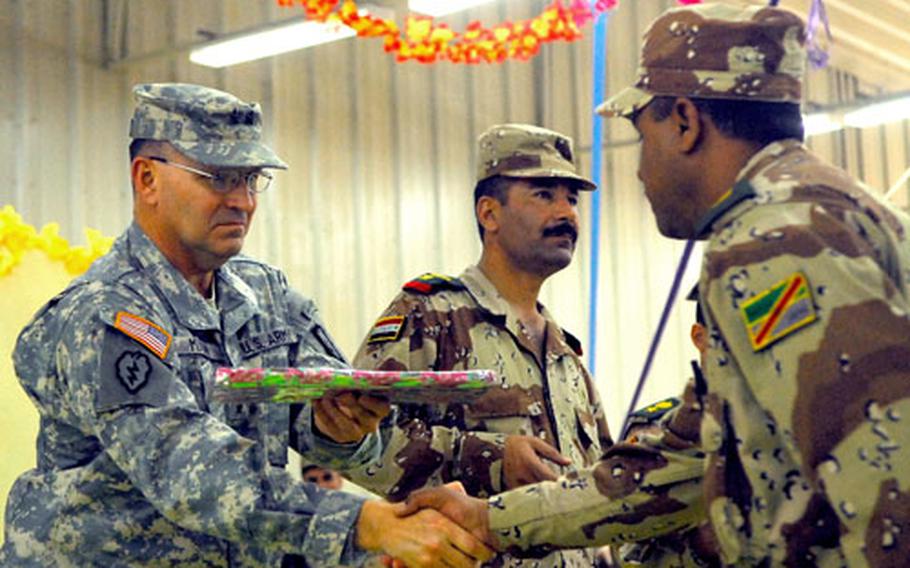 U.S. Army Maj. Gen. Benjamin R. Mixon hands a gift to an Iraqi officer during a formal transfer of authority ceremony in northern Iraq on Monday.