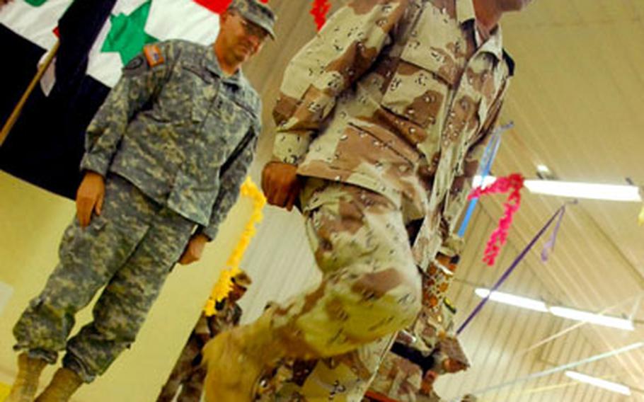An officer with the 3rd Iraqi Army Division stomps his heel in salute after being presented with a gift by U.S. Army Maj. Gen. Benjamin R. Mixon, commander of the 25th Infantry Division, at a transfer of authority ceremony in northern Iraq on Monday.