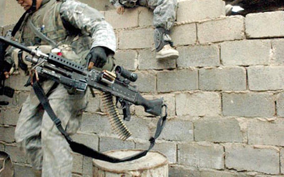 Soldiers with Company C, 1st Battalion, 6th Infantry Regiment, 2nd Brigade Combat Team scale a wall during a series of house searches in east Ramadi.