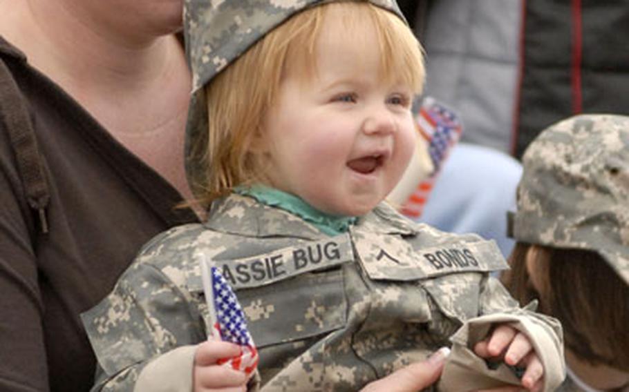 Jessica Bonds, along with her daughters Kassie and Katie (partially hidden at right), watch the 2nd Brigade Combat Team in formation during the welcome home ceremony in Baumholder. Jessica’s husband, Pfc. Jaysson Bond, is assigned to the Brigade Reconnaissance Group.