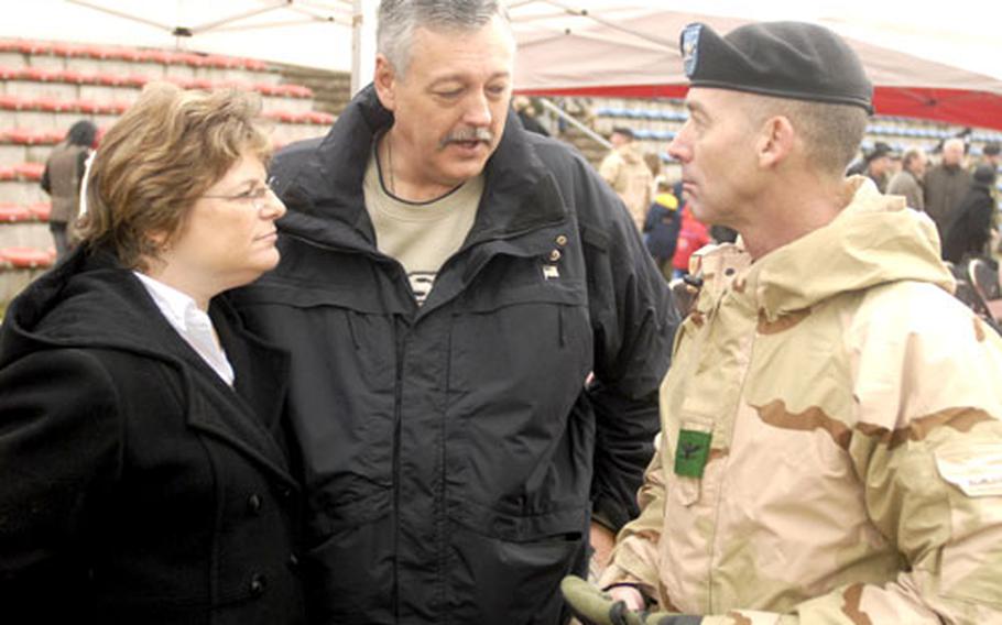 Kelly and Gary Swanson, the parents of Staff Sgt. Christopher Swanson who was killed in Iraq in July, talk with Col. Robert Scurlock after the 2nd Brigade Combat Team welcome home ceremony Wednesday in Baumholder, Germany.