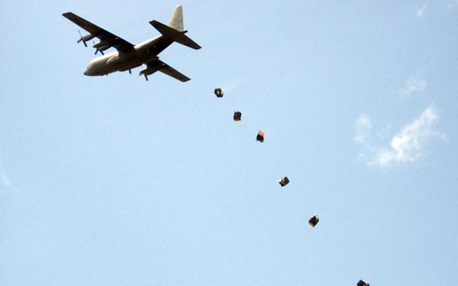 Flood-relief supplies are dropped out of a C-130 aircraft flying over the Dadaab region of Kenya.