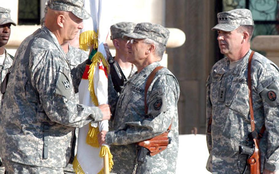 Gen. George Casey, center, the commander of all U.S. forces in Iraq, hands the flag of Multi-National Corps-Iraq to Lt. Gen. Ray Odierno, commander of the U.S. Army's III Corps, during a transfer of authority ceremony Thursday at Camp Victory in Baghdad. At right is Lt. Gen. Peter W. Chiarelli, the outgoing commander of MNC.