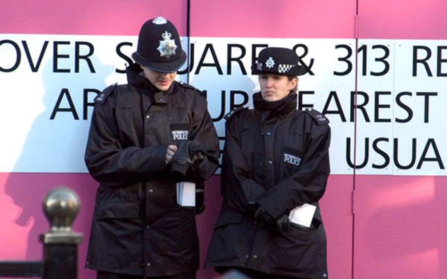 Two officers stand in front of Itsu restaurant on Piccadilly in central London. The restaurant is scheduled to reopen after Christmas.