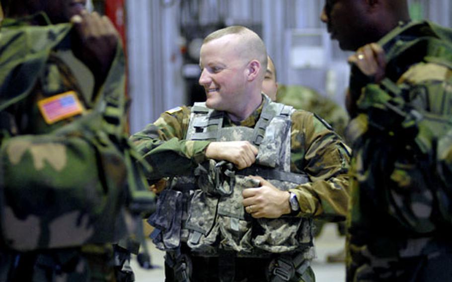 Chief Warrant Officer Thomas Hamilton, a pilot assigned to the 236th Medical Company Air Ambulance, gets fitted with the new "Air Warrior" life support equipment by Sgt. Lorenzo Chua, the NCO in charge of Aviation Life Support Equipment, at Landstuhl on Wednesday.