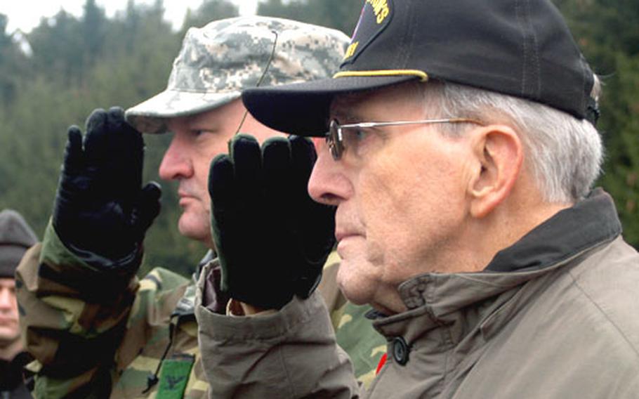 Col. Dean A. Nowowiejski, USAG Benelux commander, left, and Maurice Sperandieu, World War II veteran and founder of the annual march in Bastogne, salute during the ceremony at the 506th Parachute Intrantry Regiment monument.
