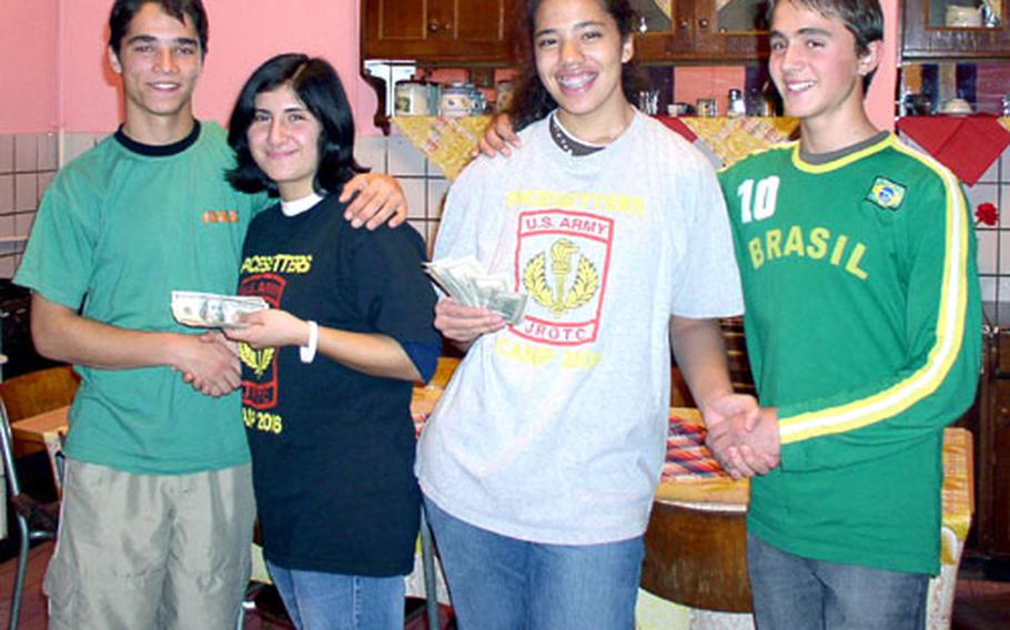 Patch High School students Jesi Perez, second from left, and Dani Thomas, second from right, smile with residents of a Santana, Romania, orphanage. The students raised $1,000 for the orphanage by bagging groceries at the commissary.