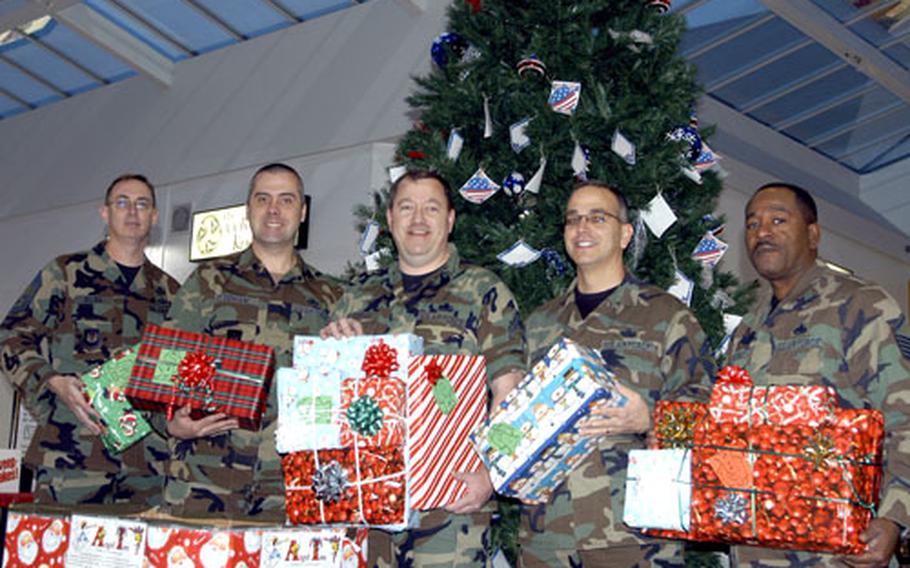 From left, Chief Master Sgt. Steve Dilda, Master Sgt. Andy Denham, Senior Master Sgt. John J. Dunham, Senior Master Sgt. Robert Loftus and Master Sgt. Larry Haynes, hold gifts donated as part of the Angel Tree program.