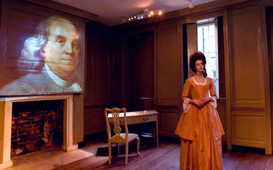 An actress playing the role of Polly Hewson, the daughter of the landlady of the house where Benjamin Franklin lived in London, stands in the famous American's parlor while an image from the 'Historical Experience' is projected on the wall.