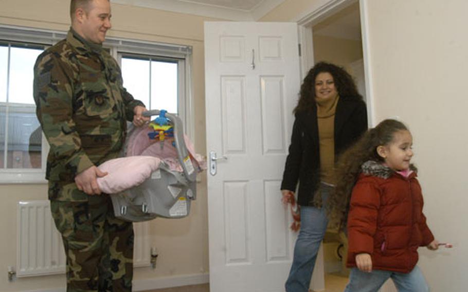 Staff Sgt. John Vohs, left, holds his 8-week-old daughter, Vannessa, as his other daughter, Alisha, 3, and wife, Brenda, tour a bedroom in their new home on Dec. 13.