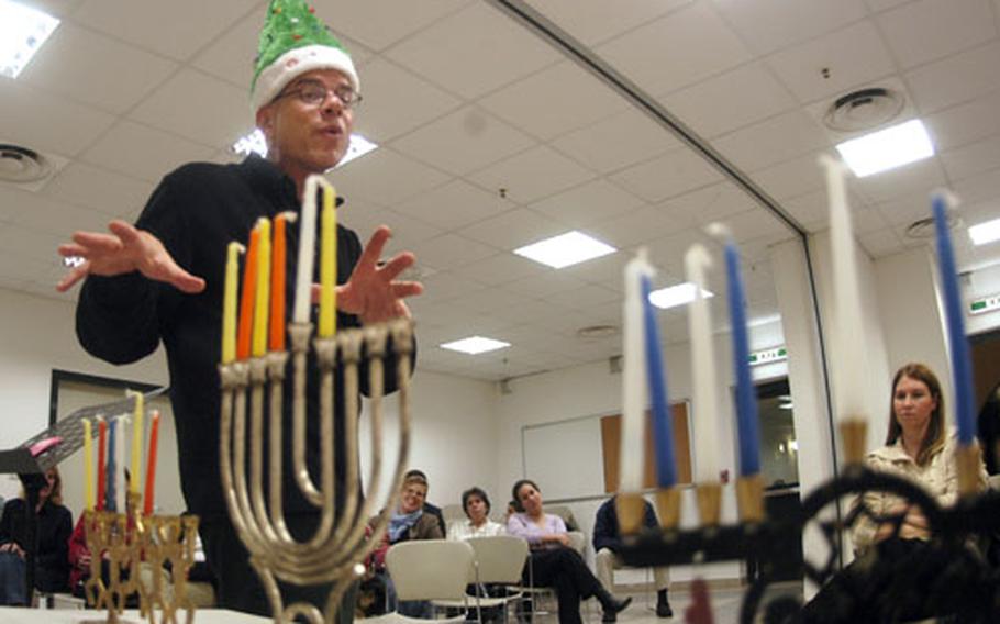 Rabbi (Lt. Cmdr.) Seth Phillips, a Navy chaplain at Naval Support Activity Naples, Italy, was invited to share Hanukkah's history and customs at the weekly meeting of the Protestant Women of the Chapel, also attended by the members of the Military Council of Catholic Women. Here, he instructs them on the process and meaning of the Jewish "festival of lights," which commemorates the rededication of the Temple of Jerusalem by the Maccabees in 165 BCE.