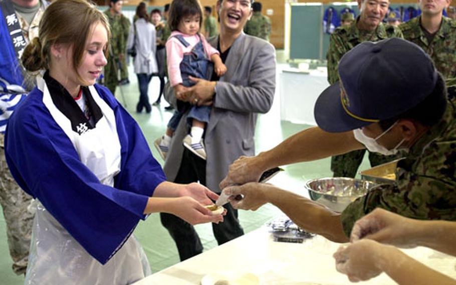 Hannah Soule, 13, the duaghter of a Marine captain, tries her hand at rolling a mochi ball at the 2006 Rice Pounding Ceremony. Soule said she didn&#39;t know what was being put in her mochi, but it was OK since her dad was going to eat that one.