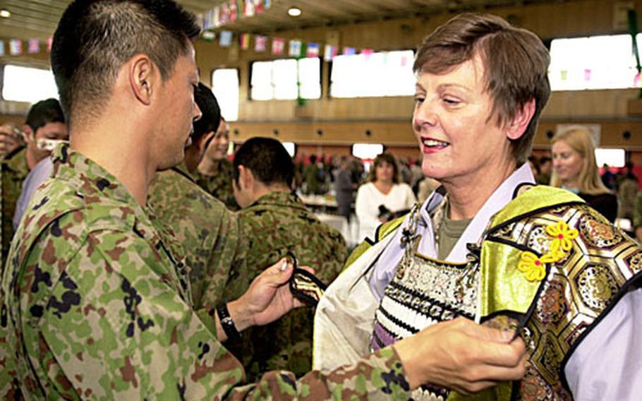 Maj. Gen. Mary Ann Krusa-Dossin, commander of Marine Corps Base Camp Butler, tries on a samuri outfit. In her opening remarks at the ceremony, Krusa-Dossin said the event was a "wonderful experience, especially for those of us new to the island" and that the American and Japanese militaries based here need more such cultural exchanges.