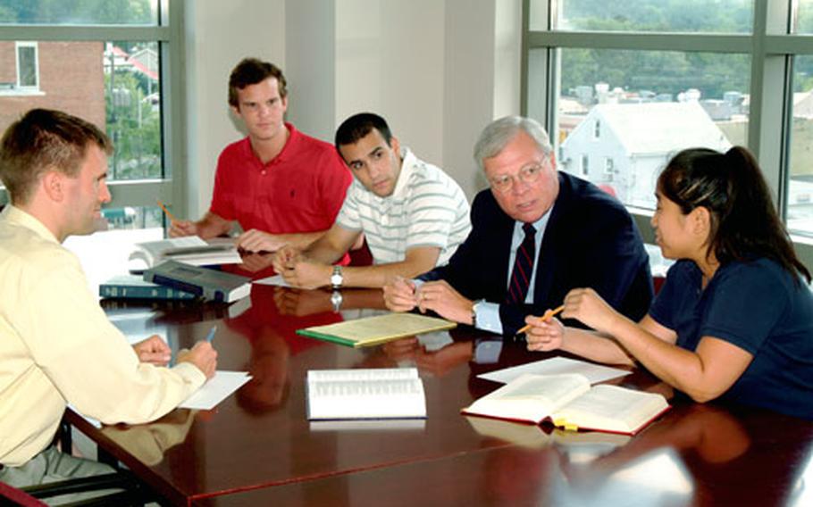 George Mason University law students talk with professor Joseph Zengerle. From left are Ben Hurwitz, Matt Conrad, Michael Miano, Zengerle and Kim Phan. Several students are helping with free legal services for servicemembers who otherwise couldn’t afford it.