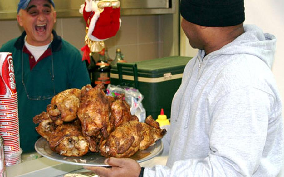 Sgt. 1st Class Deljuan Hollingshead, of the 3rd Battalion, 405th Army Field Support Brigade, right, jokes with Eleftherius Kostas about not sharing his order of rotisserie chickens with his hungry bowling team members. Kostas's Restaurant opened in conjunction with Camp Darby's Bowling center.