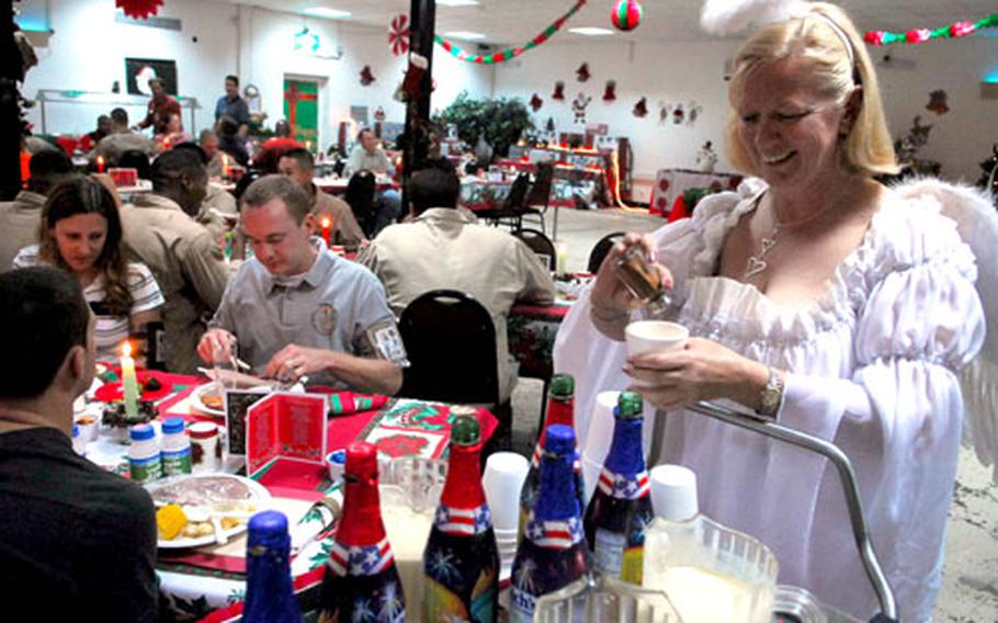Diana Jones, of Forth Worth, Texas, a laundry supervisor at Camp Lemonier Anti-Terrorism Base, serves up eggnog to Marines, sailors, soldiers and airmen during Christmas dinner Monday in Djibouti, in the Horn of Africa.