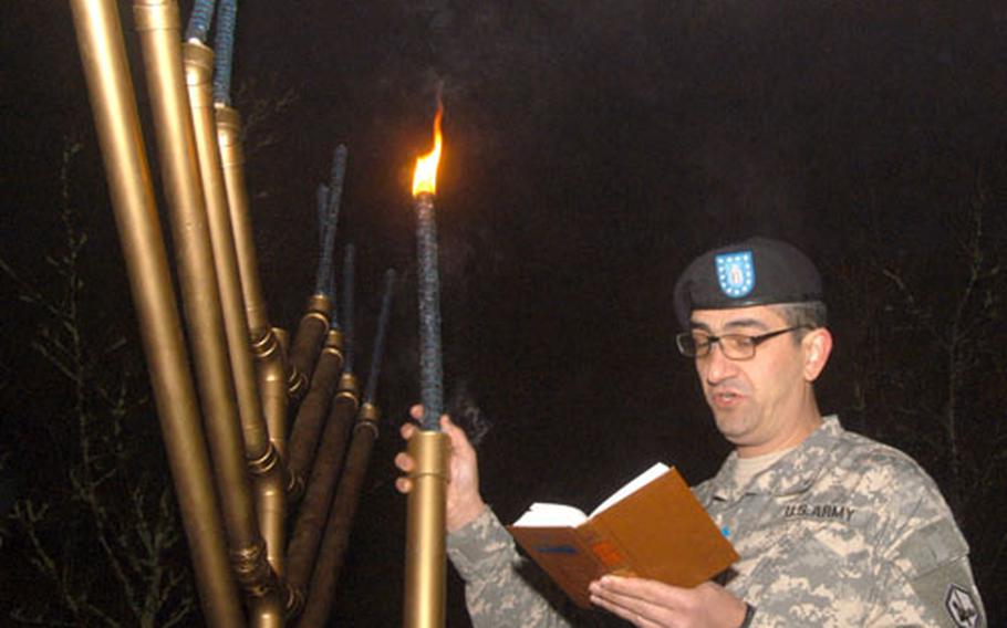 Chaplain Henry Soussan, a captain and rabbi attached to the Military Intelligence Battalion at RAF Menwith Hill, gives a sermon in front of a menorah during a Hanukkah service at RAF Lakenheath.