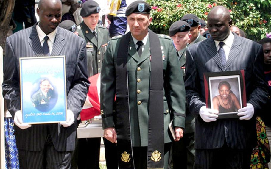 Army Chaplain (Maj.) Mark Nordstrom leads the funeral procession for Pfc. Lena Karungi, in Mbarara, Uganda on Nov. 12. Holding the photo of the V Corps soldier, who was killed in a train accident near Heidelberg in October, is a worker for the local funeral service.