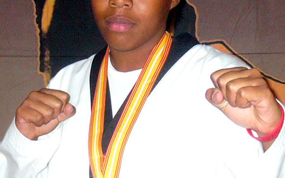 Desiree Brown, age 13, poses with her gold medal after winning first place at the 2006 South Kanto District Tae Kwon Do Championship.