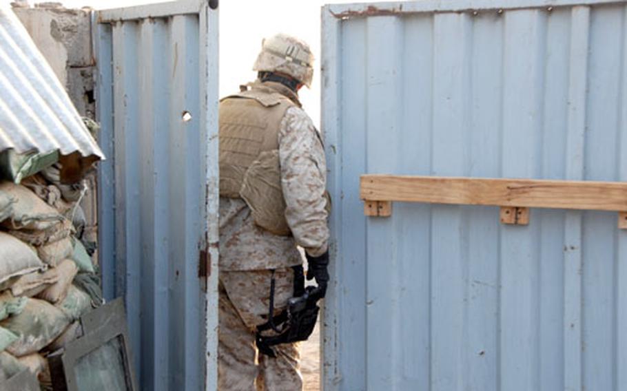 Chief Warrant Officer Bruce Broaddus walks through the gate that used to be the outermost perimeter of defense for a water pump house, before the installation of Hesco barriers and additional access gates.