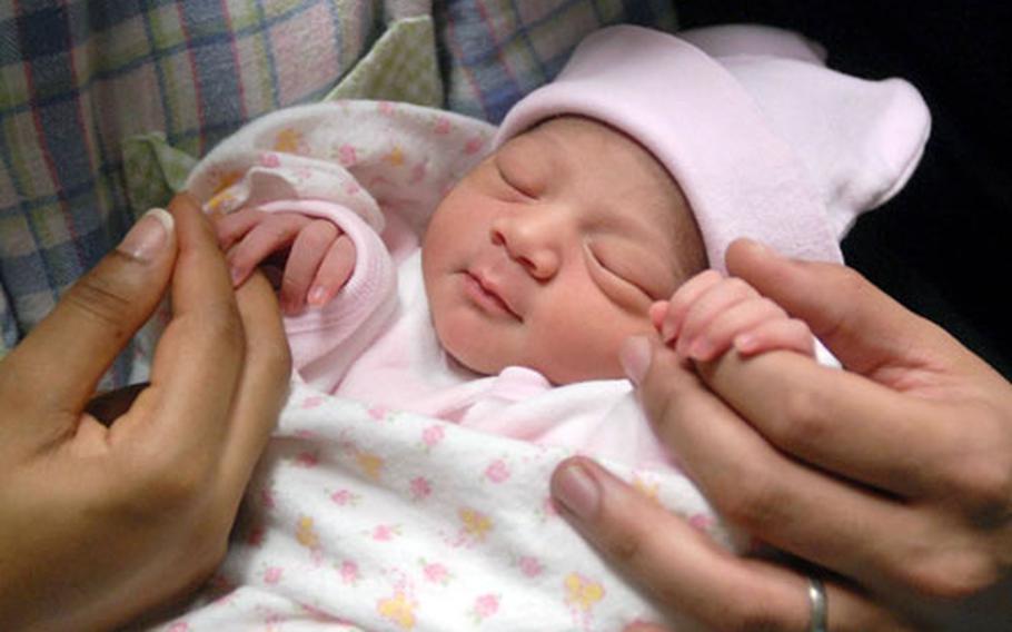 Jayla Amore Korkmaz, the first baby born at Landstuhl Regional Medical Center in 2007, holds onto her parents&#39; fingers Monday. "The most exciting part was seeing her finally,” said Angie-Lee Korkmaz. “The whole pregnancy was perfect.”