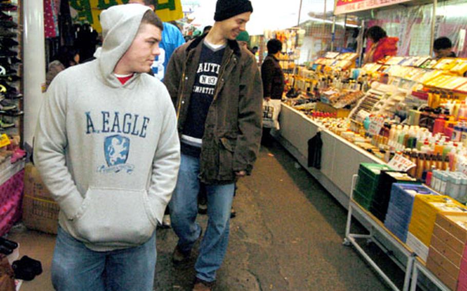 Soldiers walk through an open market last month during an orientation program at Camp Henry.