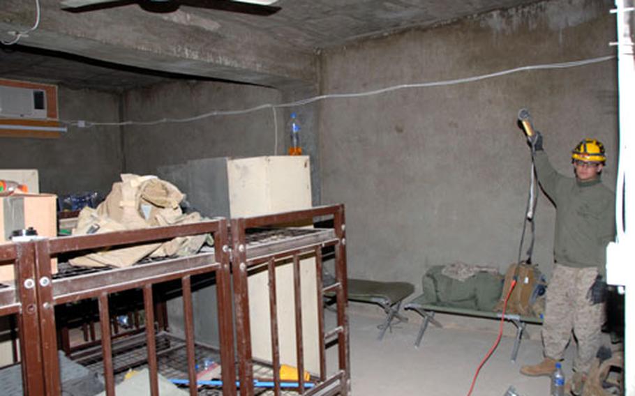 Cpl. Matthew Kimball, 23, holds up a portable light in one of the rooms where Iraqi army soldiers sleep in the bunker.