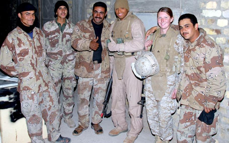 Sgt. Garival Perez, third from right, and Cpl. Victoria Wellman relax with Iraqi army soldiers during a renovation project of the Army’s living quarters. The soldiers are eager to have their photos taken with the Marines and ask to do so often.