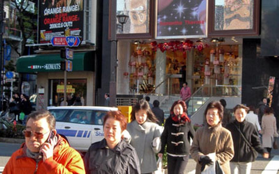 Japanese citizens walk past a large billboard of American star Beyonce Knowles in Tokyo.