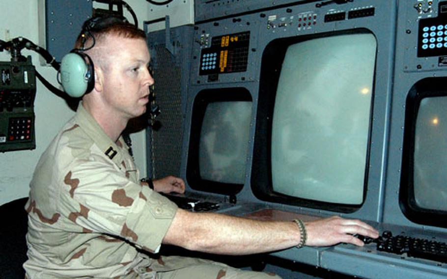 Capt. Eric Figueriedo, a member of the 322nd Expeditionary Air Control Squadron, sits inside an operations module while deployed to Balad Air Base in Iraq in 2004.