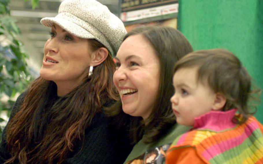 Country music star Jo Dee Messina, left, poses for a photo with Kathleen Ramirez and her 19-month old daughter, Sofia, during an autograph session Saturday at Aviano Air Base, Italy.