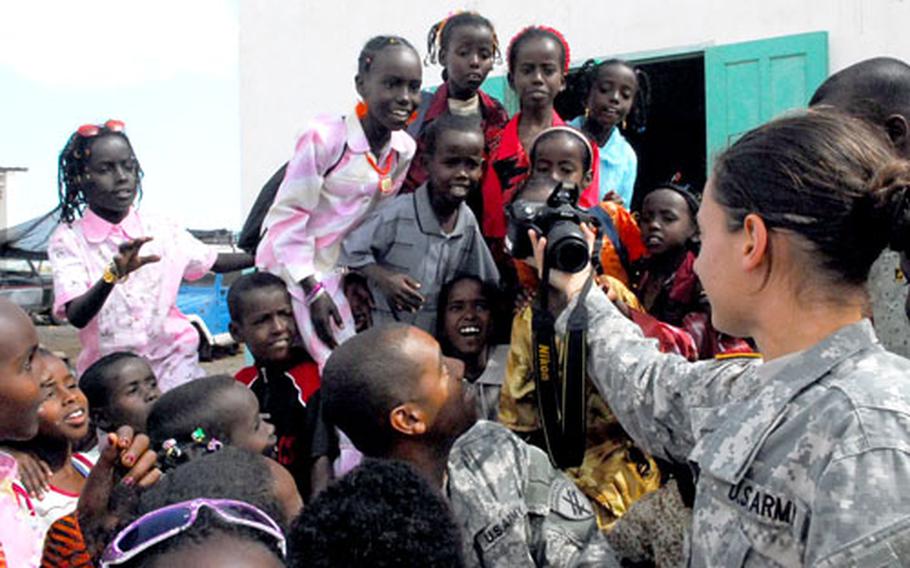 U.S. Army Cpl. Nicole Deal, 20, of Mishawaka, Ind., shows nomadic children a photo she took of them during a visit Saturday to their school on the outskirts of Djibouti City.