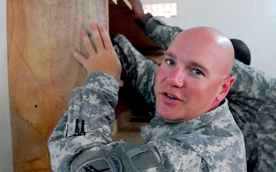 U.S. Army Capt. Jason Fleming, 36, of Chattanooga, Tenn., helps install a new bookshelf at a library in Djibouti City on Saturday.