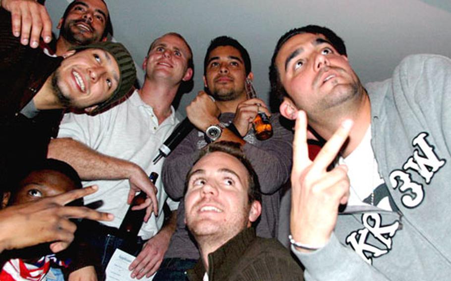 Wilmer Valderrama, top-center with microphone, poses with performers and audience members Friday after a show at Kelley Lounge at Kelley Barracks in Stuttgart, Germany.