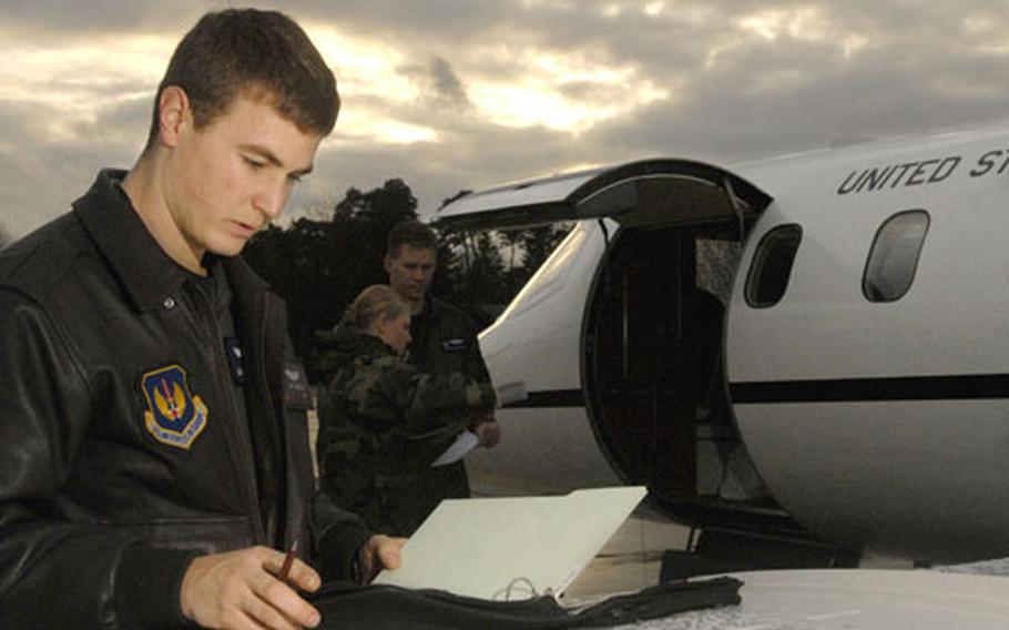 Capt. Matt Dudderar, a pilot assigned to the 76th Airlift Squadron, checks the maintenance forms on the C-21.