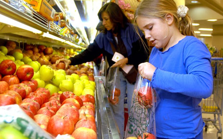 Eating healthy is one of the top New Year&#39;s resolutions, as demonstrated by Grace Le Moyne&#39;s careful apple selection at the Yokosuka Commissary Monday.