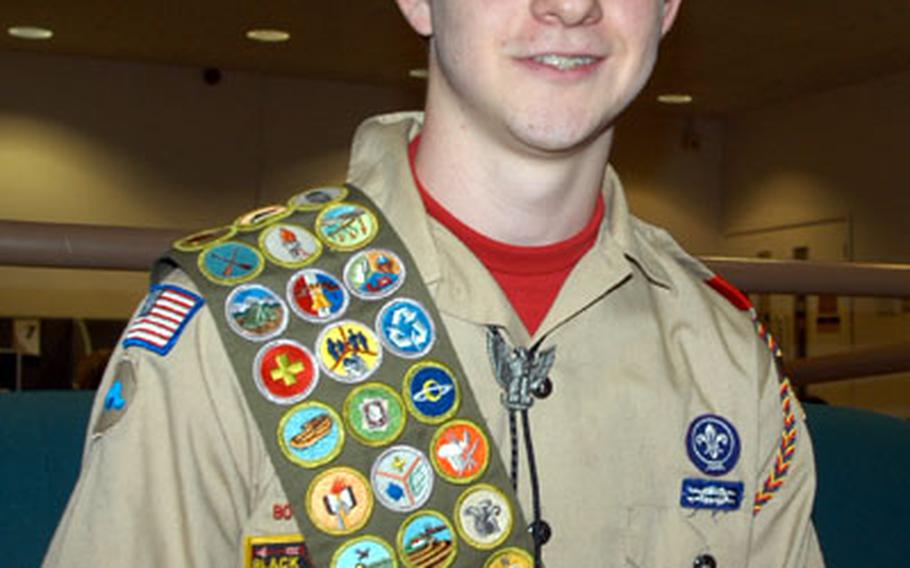 Eagle Scout Justin Goss dons his merit badge sash.