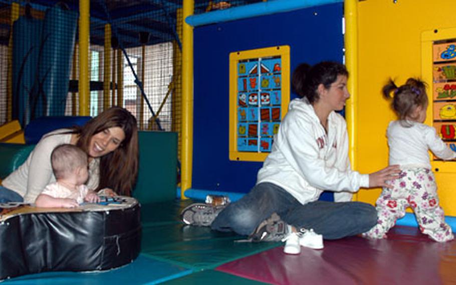 Desiree Collert and her 4-month-old daughter, Ella, left, play alongside friends Sarah Cunningham and her 9-month-old daughter Hannah at the newly reopened Bob Hope Center Kids Zone on RAF Mildenhall.