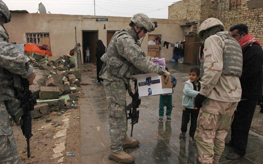 1st Lt. Josh Mantz, 23, of Sunbury, Pa., of the 1st Battalion, 8th Cavalry Regiment, 2nd Brigade Combat Team, brings socks and warm children’s clothes to the family affected by a U.S. artillery strike in late December. His mother rushed the package to Iraq after hearing about the family from Mantz, who found the Iraqis while his unit was doing a foot patrol near Sadr City last week.