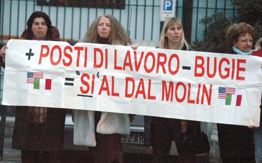 Italian workers supporting the U.S. use of Dal Molin airfield in Vicenza, Italy, hold a sign that loosely translates into: "Additional jobs minus lies equals &#39;yes&#39; on Dal Molin."