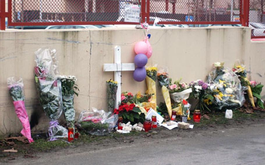 Flowers, candles and notes are left at the wall of Area 1 at Aviano Air Base, Italy, where Vanessa Rita Russo, an 18-year-old senior at Aviano High School, was killed in an automobile accident early Sunday morning.