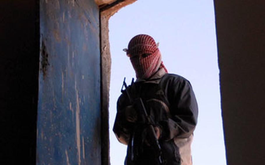 An Iraqi policeman searches a home suspected to be a base of operations for insurgents. Like most of the Albu Faraj officers, he wears a scarf to hid his identity for safety reasons. Iraqi Border Police Col. Yousef Tariq, who is represents police officers in Jazeera where Albu Faraj is located, said he is against the practice of concealing identities, but added that as places become more secure the police officers feel more comfortable to reveal who they are. "Slowly but surely we&#39;ll get to where we want to be," he said.