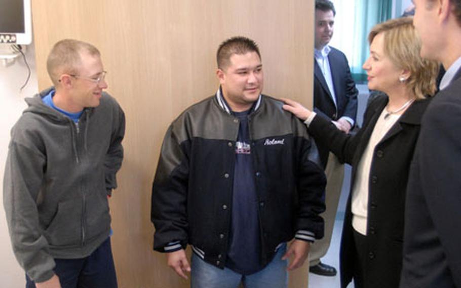 Senators Hillary Rodham Clinton (D-NY) and Evan Bayh (D-IN) visit with Army Sgt. Kenneth Gibson, left, and his friend Spc. Roland Ada at Landstuhl Regional Medical Center in Germany on Monday. Ada drove in to visit a friend who was wounded in Iraq. Both are assigned to the 127th Military Police Company stationed in Hanau.