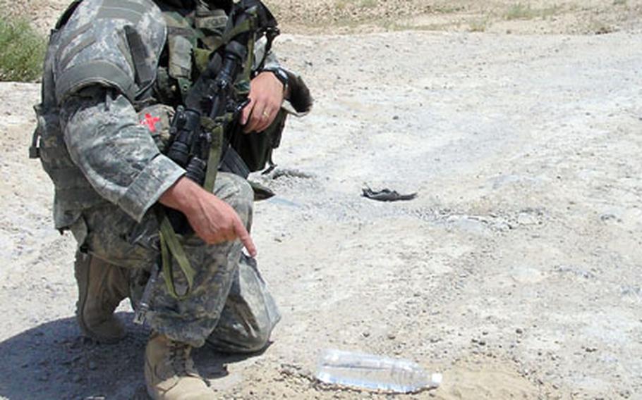 Sgt. 1st Class Michael McGuire, with the Company A, 40th Engineer Battalion, points at an explosive found by his unit last year near Ramadi, Iraq. McGuire wrote dispatches from Iraq for Peter King&#39;s column on Sports Illustrated&#39;s Website.