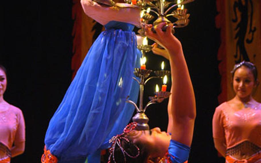 Chinese State Circus contortionist Liu Cen, center, keeps five lit candelabras aloft and upright in a warm-up session at the Cambridge Corn Exchange recently.