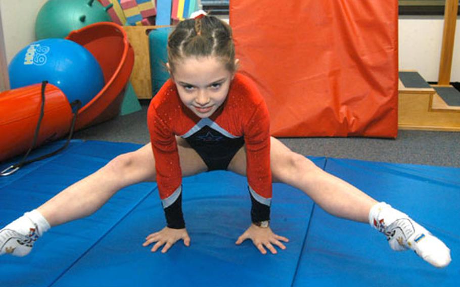 Gymnast Rachel Pagio picks herself up off a mat at Alconbury Elementary School, then stood herself up in a handstand without her feet touching the floor in a strength-training exercise.