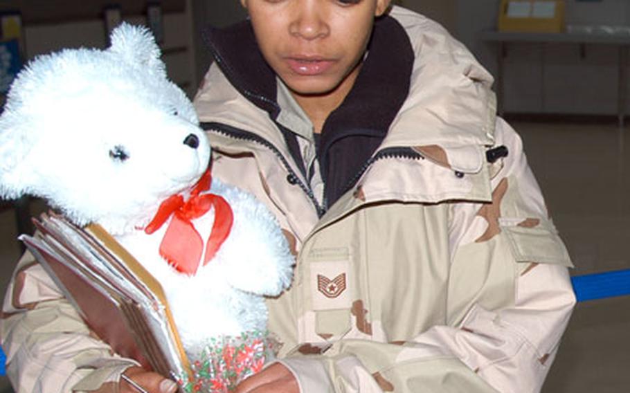 Tech. Sgt. Crystal Deann Burnett, 34, an avionics technician with the 35th Aircraft Maintenance Squadron, clutches her stuffed bear, Solace, while waiting in the deployment out-processing line Wednesday morning at Misawa Air Base, Japan. “Solace goes to war,” Burnett said, as she got her photo taken.